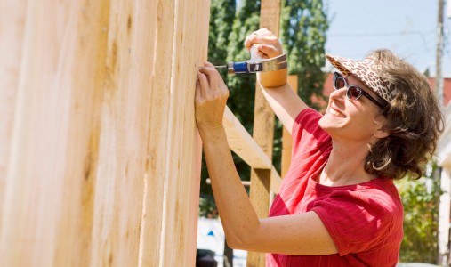 Smiling woman building fence